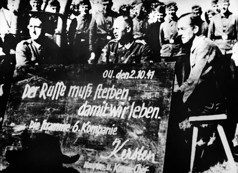 Коллективная фотография немецких военнослужащих около школьной доски с надписью: «Русские должны умереть, чтобы мы жили»  