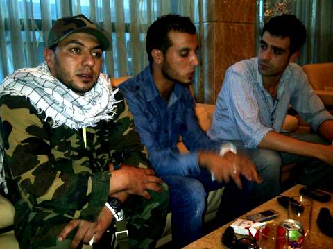 Мухаммед Юма аль-Шошни, в джинсовой куртке, утверждает, что он убил Мутассима, сына Каддафи.  