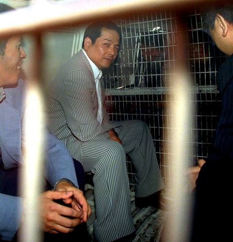 Главаря филиала гонконгской группировки 14К в Макао Вань Квоккоя по кличке Сломанный зуб везут в суд 23 ноября 1999 года