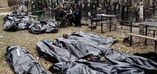 Поліцейські поруч із тілами загиблих під час російської окупації Бучі на місцевому кладовищі, квітень 2022 року