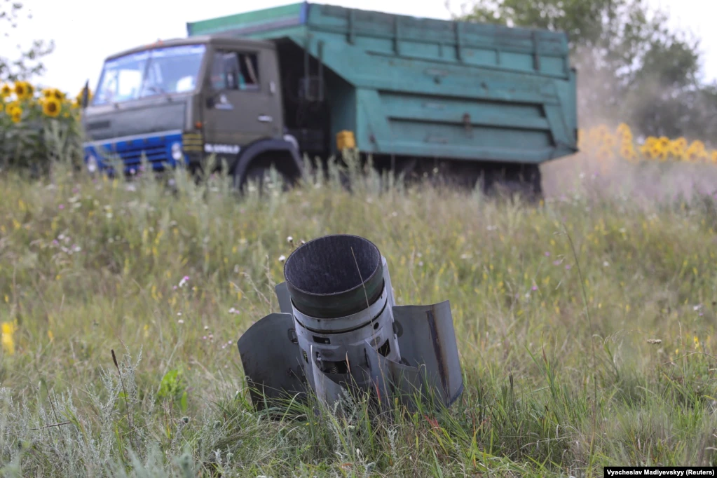 Вантажівка з пшеницею проїжджає повз хвостову частину ракети, що впала і застрягла в полі в Харківській області, фото від 30 липня