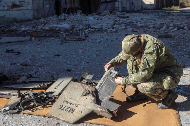 REUTERS Підпис до фото, Український правоохоронець досліджує уламки іранського дрону "Шахед-136", що атакував інфраструктурний об'єкт в Харкові 6 жовтня 2022 року