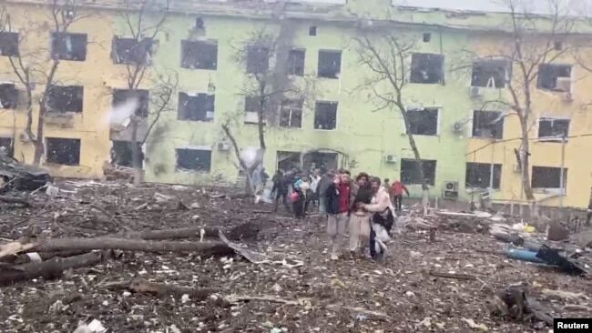 Маріуполь. Люди виводять поранених із дитячої лікарні та пологового, куди влучила російська бомба. 9 березня 2022 року