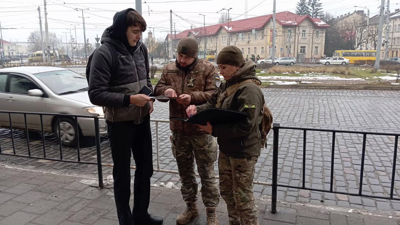 Працівники ТЦК виписують повістку.