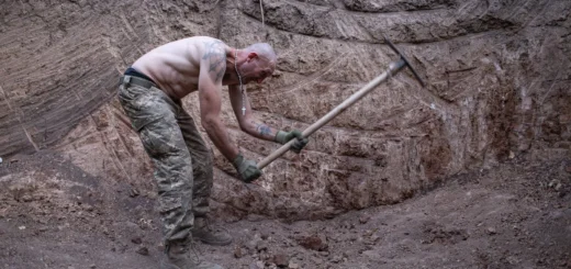 Позивний «Локомотив» з-поміж колишніх ув’язнених киркою заглиблює яму для бліндажу. Польовий табір 1 ОШП ім. Дмитра Коцюбайла, 19 серпня 2025 року. Андрій Дубчак / Frontliner