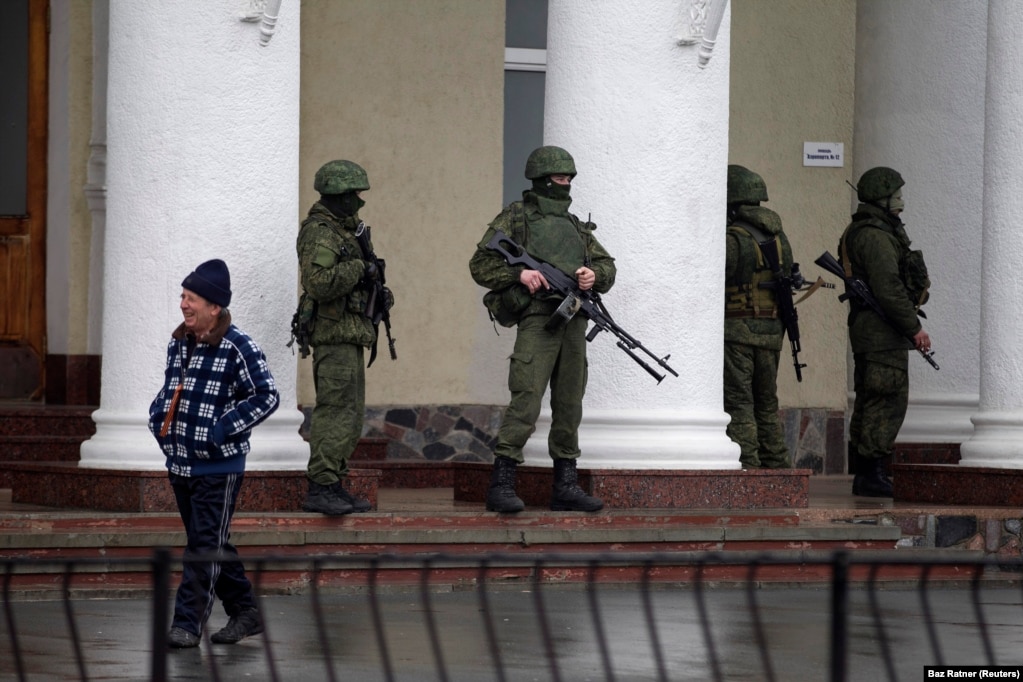 Російські «зелені чоловічки» біля будівлі аеропорту в Сімферополі. 28 лютого 2014 року. Анексія Криму почалась під час зимової Олімпіади в російському Сочі