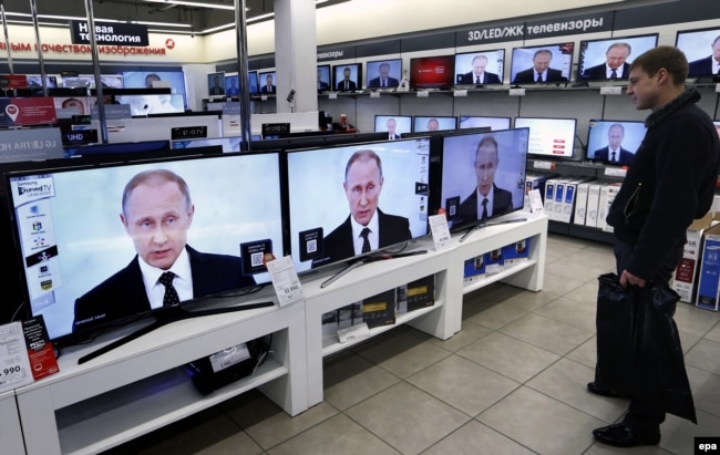 Демонстрація виступу президента РФ Володимира Путіна на екранах телевізорів у торговому центрі в Москві, архівне фото