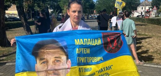 Аліна тримає прапор із портретом свого безвісти зниклого чоловіка. Фото з особистого архіву Аліни