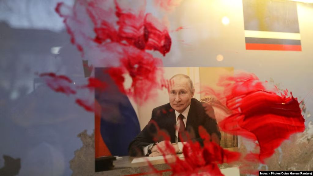Розмазаний червоною фарбою портрет очільника Росії Володимира Путіна під час антивоєнної акції біля російського посольства в Румунії. Бухарест, 26 лютого 2022 року