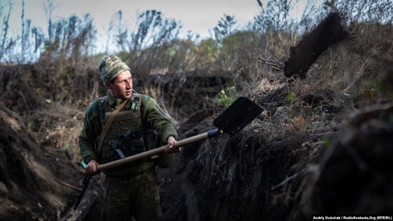 Украинский военный копает окоп на запасных позициях в зоне потенциального разведения войск, Богдановка