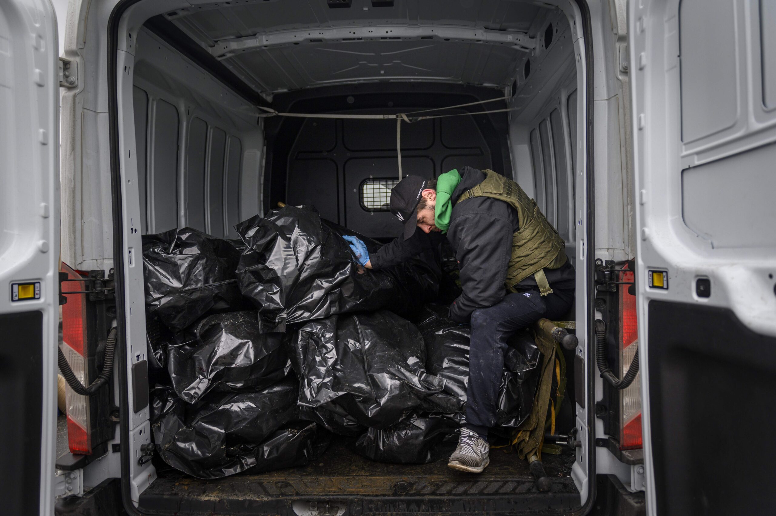 Волонтер сидит в грузовике с мертвыми телами перед их транспортировкой к братской могиле в Буче. Фото: Christopher Occhicone