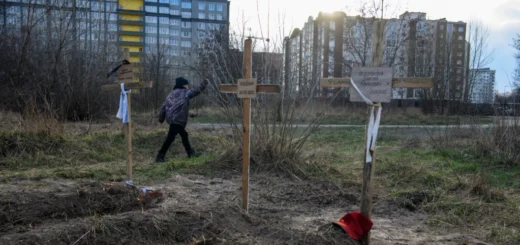 Мальчик проходит мимо могил с телами мирных жителей, которые, по словам местных жителей, были убиты российскими солдатами в Буче.
