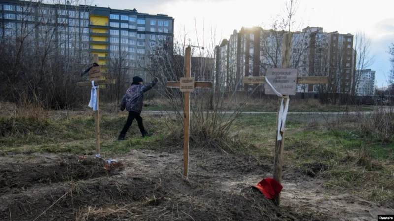 Мальчик проходит мимо могил с телами мирных жителей, которые, по словам местных жителей, были убиты российскими солдатами в Буче.