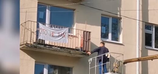 Коммунальщики с подъемником снимают простыню с надписью «Это не флаг». Скриншот видео TUT.BY