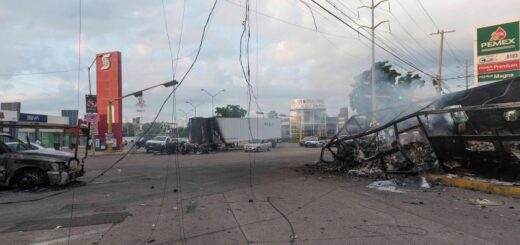Сгоревшие автомобили, использованные боевиками, тлеют на перекрестке через день после уличных боев с силами безопасности в Кулиакане 18 октября. Аугусто Зурита — AP