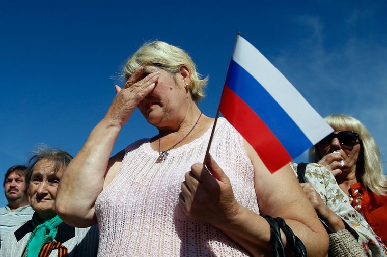 Женщина с российским флагом плачет во время парада в Луганске на востоке Украины, 14 сентября 2014 года Фото: Darko Vojinovic / AP
