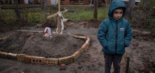 У дворі свого будинку 6-річний Влад Танюк стоїть біля могили матері Ірини, яка померла від голоду та стресу через війну на Київщині, 4 квітня 2022 року Фото: AP Photo / Rodrigo Abd